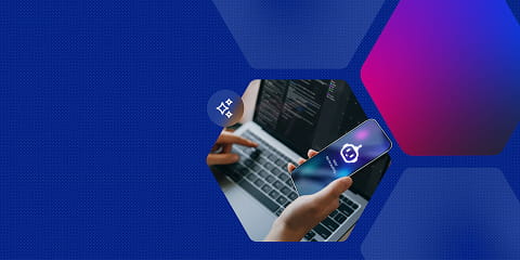 A person holding a smartphone displaying an AI assistant icon while working on a laptop with code on screen, representing the top AI skills for 2026.