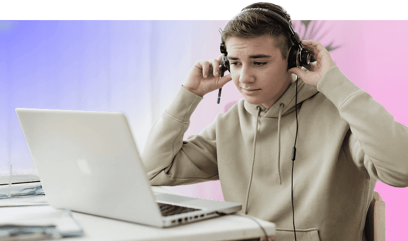 A boy wearing headphones looking at a laptop during an online session.